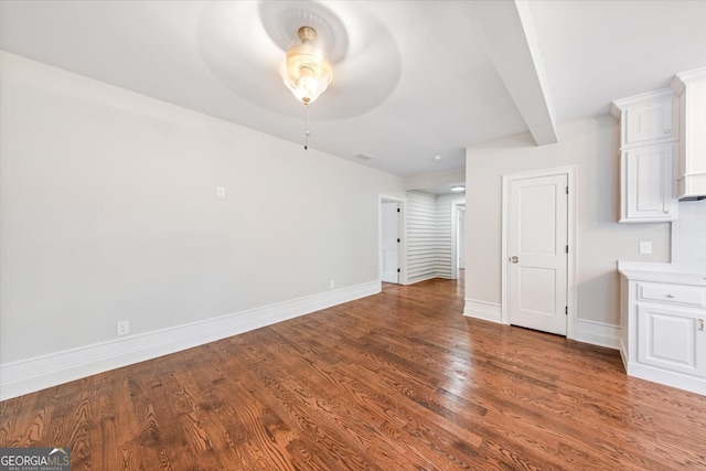 unfurnished living room featuring ceiling fan and dark hardwood / wood-style flooring