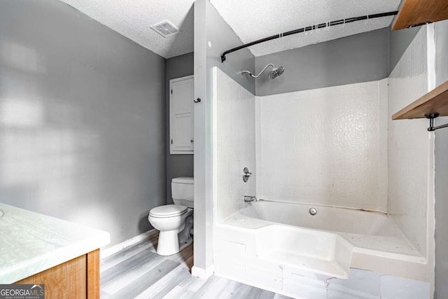 full bathroom featuring wood-type flooring, toilet, vanity, a textured ceiling, and shower / bathing tub combination