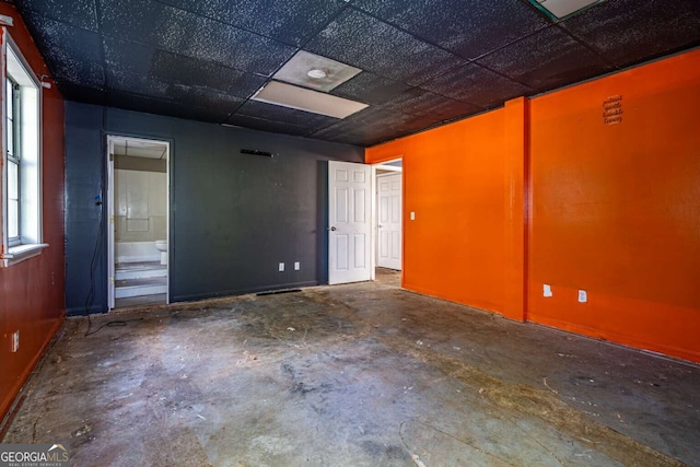 empty room featuring concrete flooring and a drop ceiling