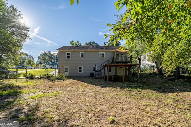 back of property featuring a deck and a lawn