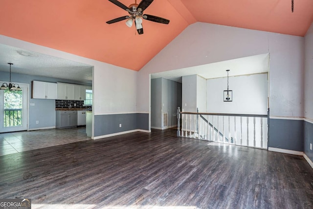 unfurnished living room featuring vaulted ceiling, ceiling fan, and dark hardwood / wood-style floors