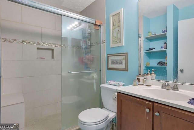 bathroom with vanity, a shower with shower door, a textured ceiling, and toilet