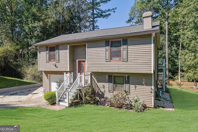 raised ranch with a front yard and a garage