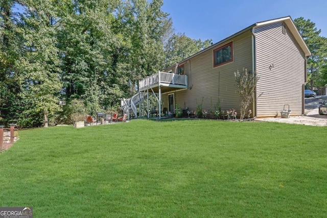 rear view of property with a wooden deck and a lawn