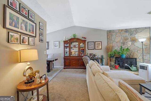 carpeted living room with a fireplace and vaulted ceiling