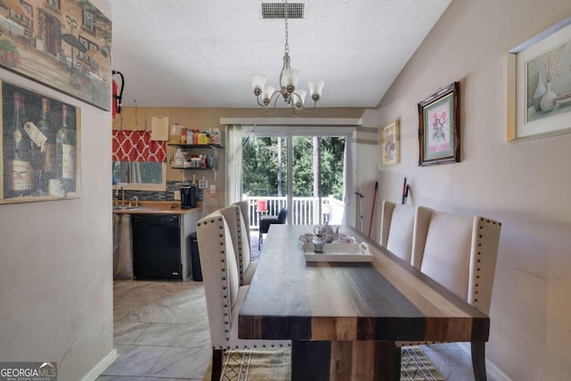 dining area featuring a notable chandelier, a textured ceiling, sink, and lofted ceiling