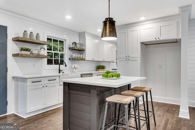 kitchen with open shelves, light countertops, backsplash, and dark wood-style flooring