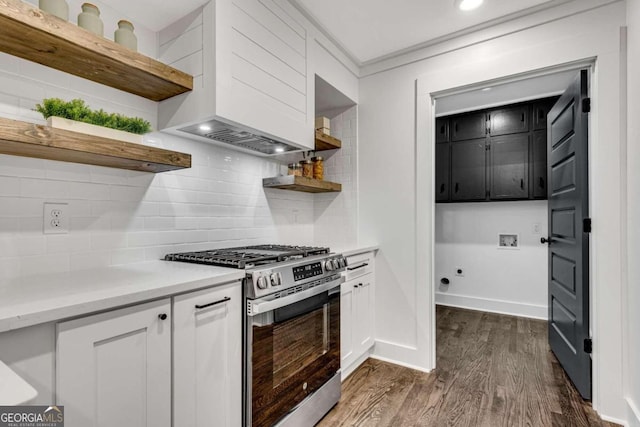 kitchen featuring stainless steel range with gas cooktop, wall chimney range hood, open shelves, backsplash, and dark wood-style flooring