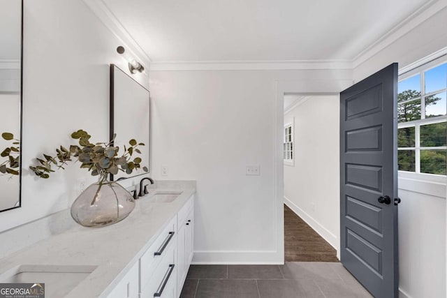 bathroom with ornamental molding, tile patterned floors, a sink, and double vanity