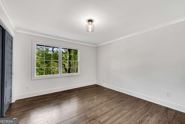 spare room with baseboards, dark wood-type flooring, and ornamental molding