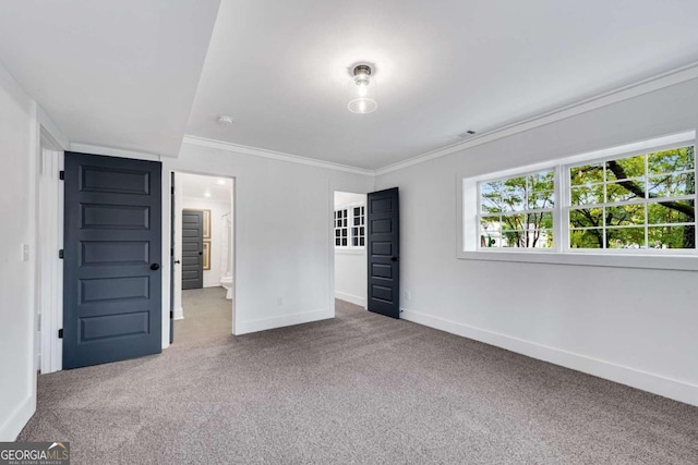 unfurnished bedroom featuring baseboards, carpet floors, and crown molding