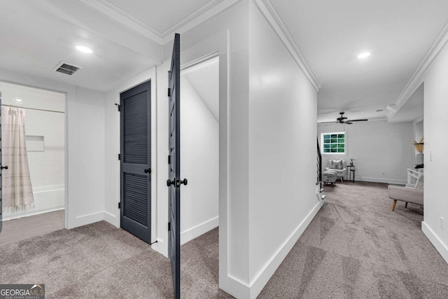 hallway with crown molding, carpet flooring, and visible vents
