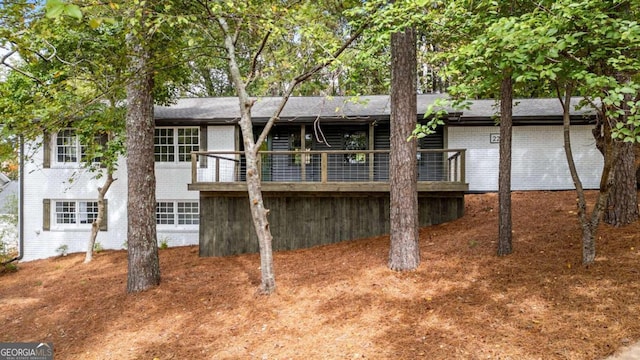 back of property with brick siding and a deck