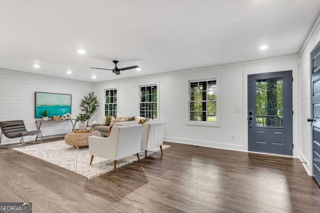 living room featuring dark wood-type flooring, ceiling fan, ornamental molding, and recessed lighting
