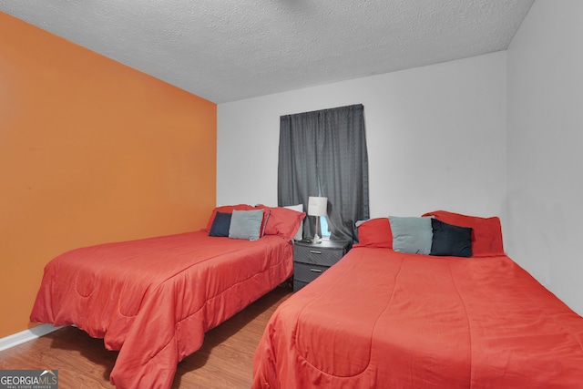 bedroom with a textured ceiling and hardwood / wood-style floors