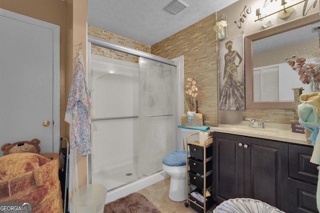 bathroom with walk in shower, vanity, toilet, and a textured ceiling