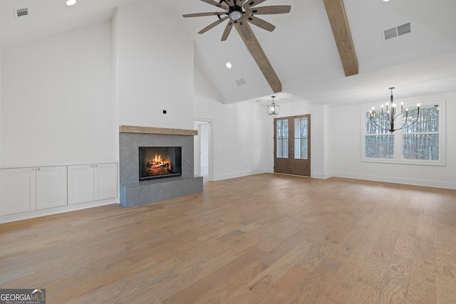 unfurnished living room featuring french doors, high vaulted ceiling, a high end fireplace, beam ceiling, and light hardwood / wood-style floors