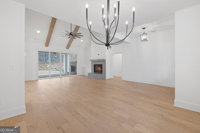 unfurnished living room with beam ceiling, ceiling fan, light wood-type flooring, and a fireplace