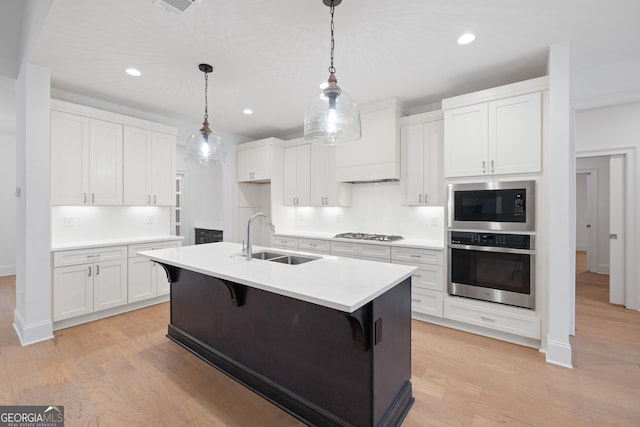 kitchen featuring stainless steel appliances, sink, and white cabinets