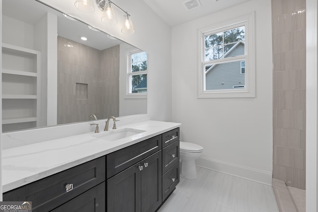 bathroom with vanity, a shower, and toilet