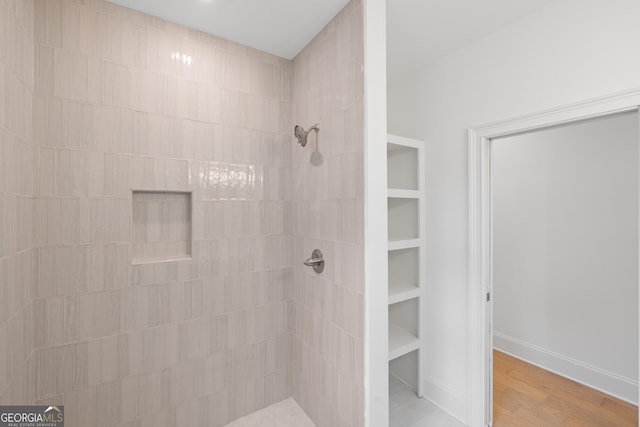 bathroom featuring wood-type flooring and tiled shower