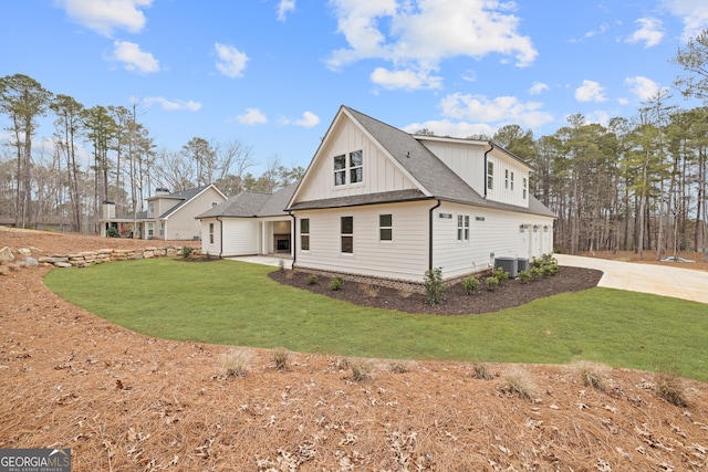 rear view of house featuring a yard and central AC unit