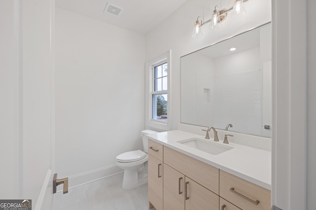 bathroom featuring vanity, toilet, and a shower