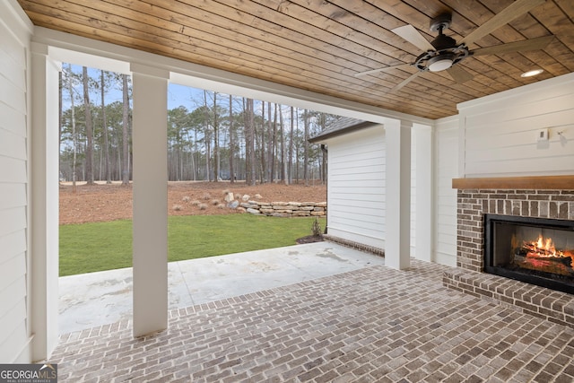 view of patio featuring an outdoor brick fireplace and ceiling fan