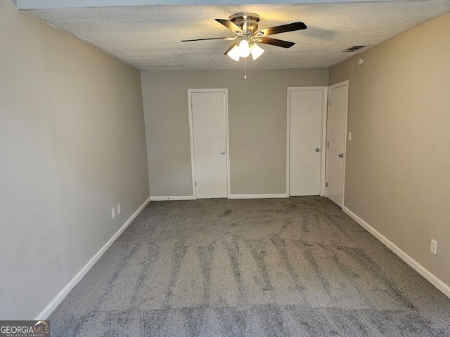 carpeted spare room with ceiling fan and a textured ceiling