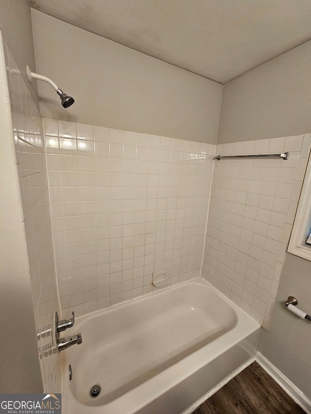 bathroom featuring tiled shower / bath combo and hardwood / wood-style floors