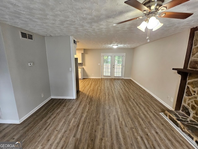 unfurnished living room featuring french doors, a textured ceiling, dark hardwood / wood-style floors, and ceiling fan