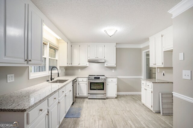 kitchen featuring sink, white cabinetry, stainless steel appliances, crown molding, and light hardwood / wood-style flooring