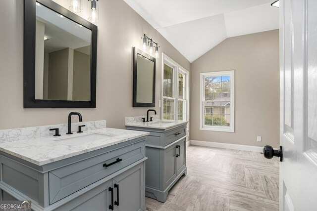 bathroom with vanity, lofted ceiling, and parquet flooring