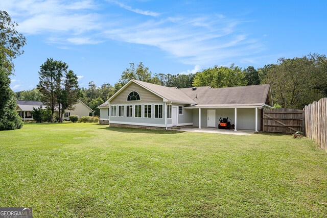 rear view of house with a patio area and a lawn