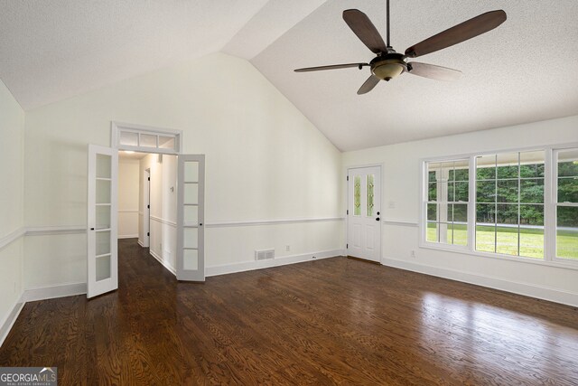 empty room with french doors, vaulted ceiling, dark hardwood / wood-style flooring, a textured ceiling, and ceiling fan