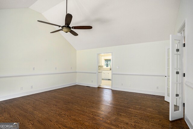 spare room with dark hardwood / wood-style floors, ceiling fan, and vaulted ceiling