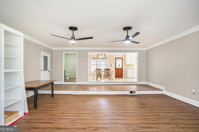 interior space with a textured ceiling, ornamental molding, and hardwood / wood-style floors