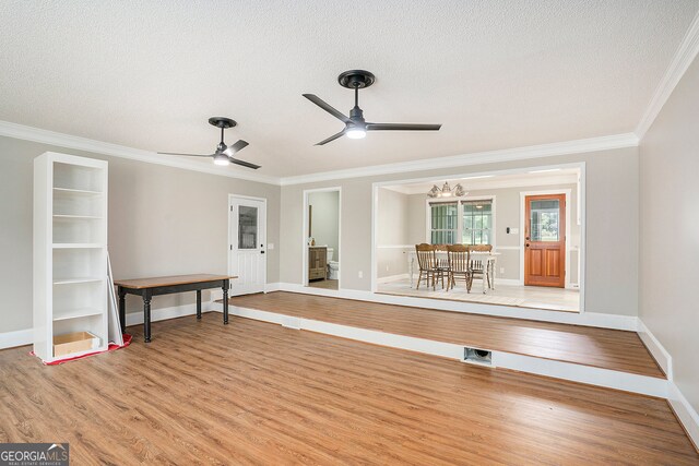 interior space featuring crown molding, wood-type flooring, and a textured ceiling