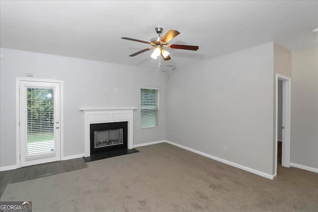 unfurnished living room with dark carpet and ceiling fan