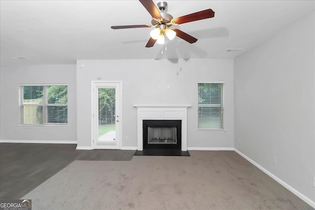 unfurnished living room with dark carpet and ceiling fan