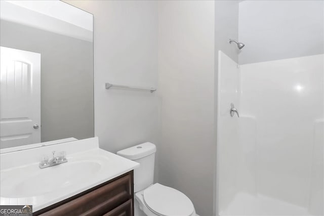 bathroom featuring walk in shower, vanity, and toilet