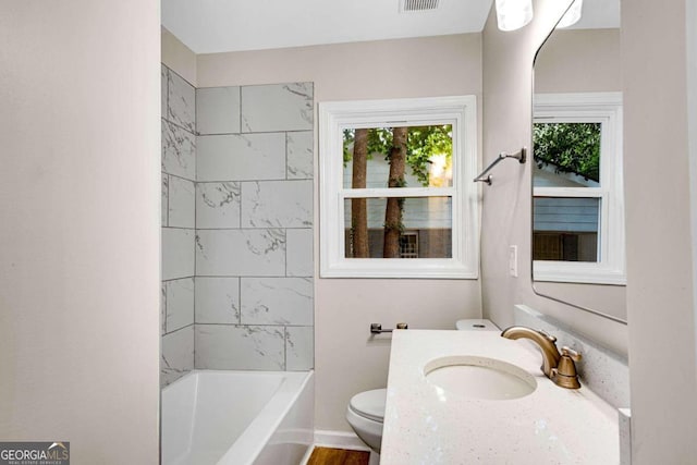 full bathroom featuring wood-type flooring, vanity, toilet, and tiled shower / bath combo