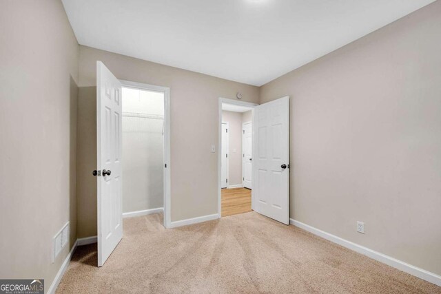 unfurnished bedroom featuring light carpet