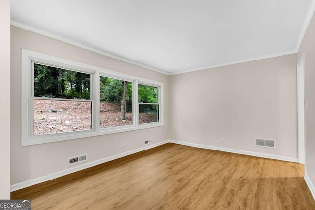 empty room featuring light hardwood / wood-style floors and ornamental molding