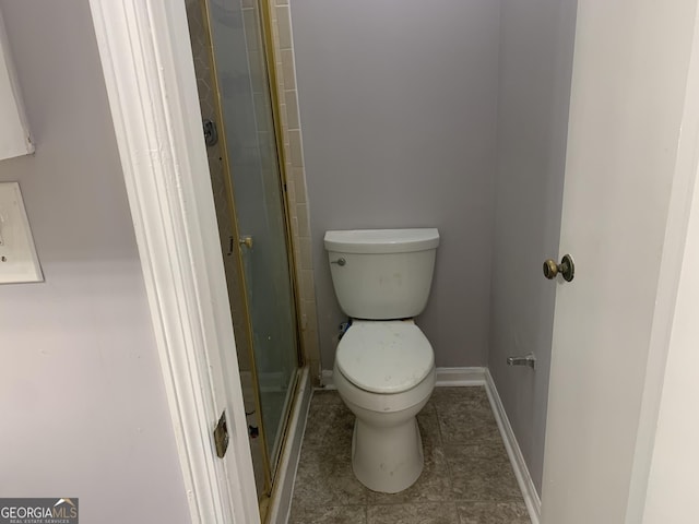 bathroom with toilet and a shower with shower door