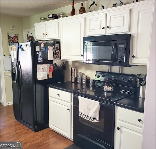 kitchen featuring black appliances, a textured ceiling, white cabinetry, and dark wood-type flooring