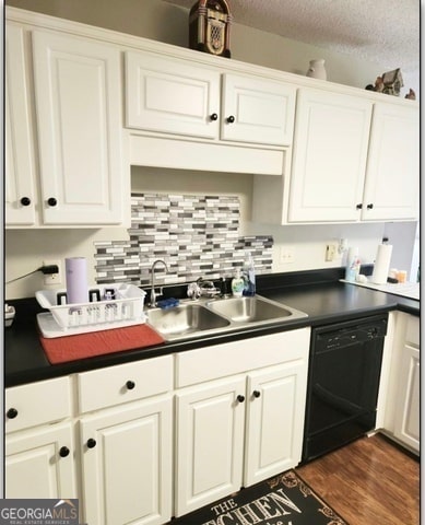 kitchen featuring dishwasher, a textured ceiling, dark hardwood / wood-style floors, and sink