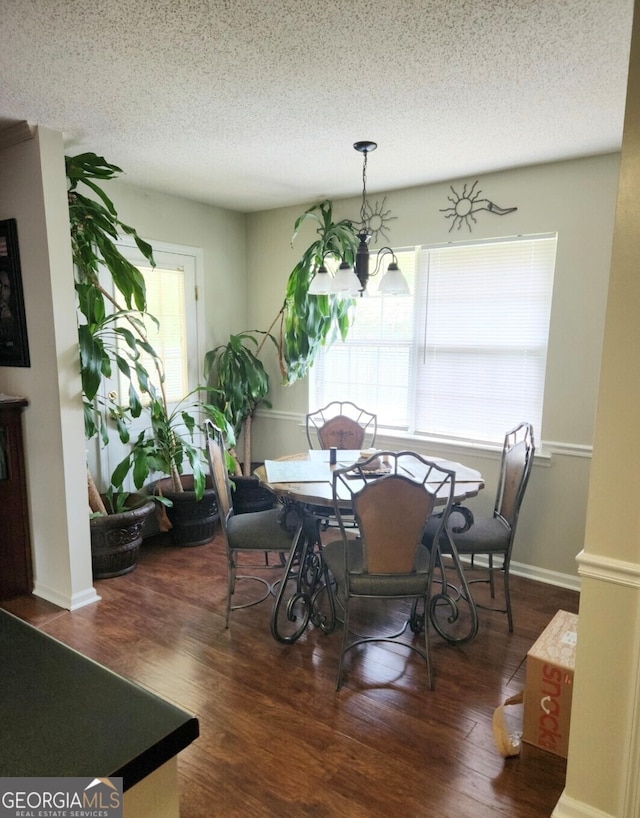 dining room with a textured ceiling, a chandelier, and dark hardwood / wood-style flooring