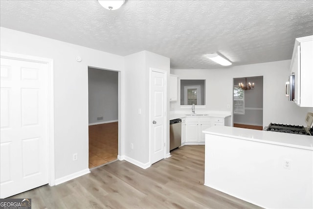 kitchen with stainless steel appliances, white cabinets, light hardwood / wood-style floors, and a textured ceiling