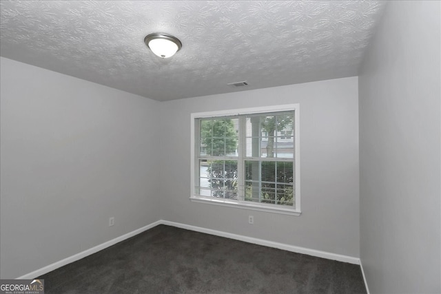 carpeted spare room featuring a textured ceiling